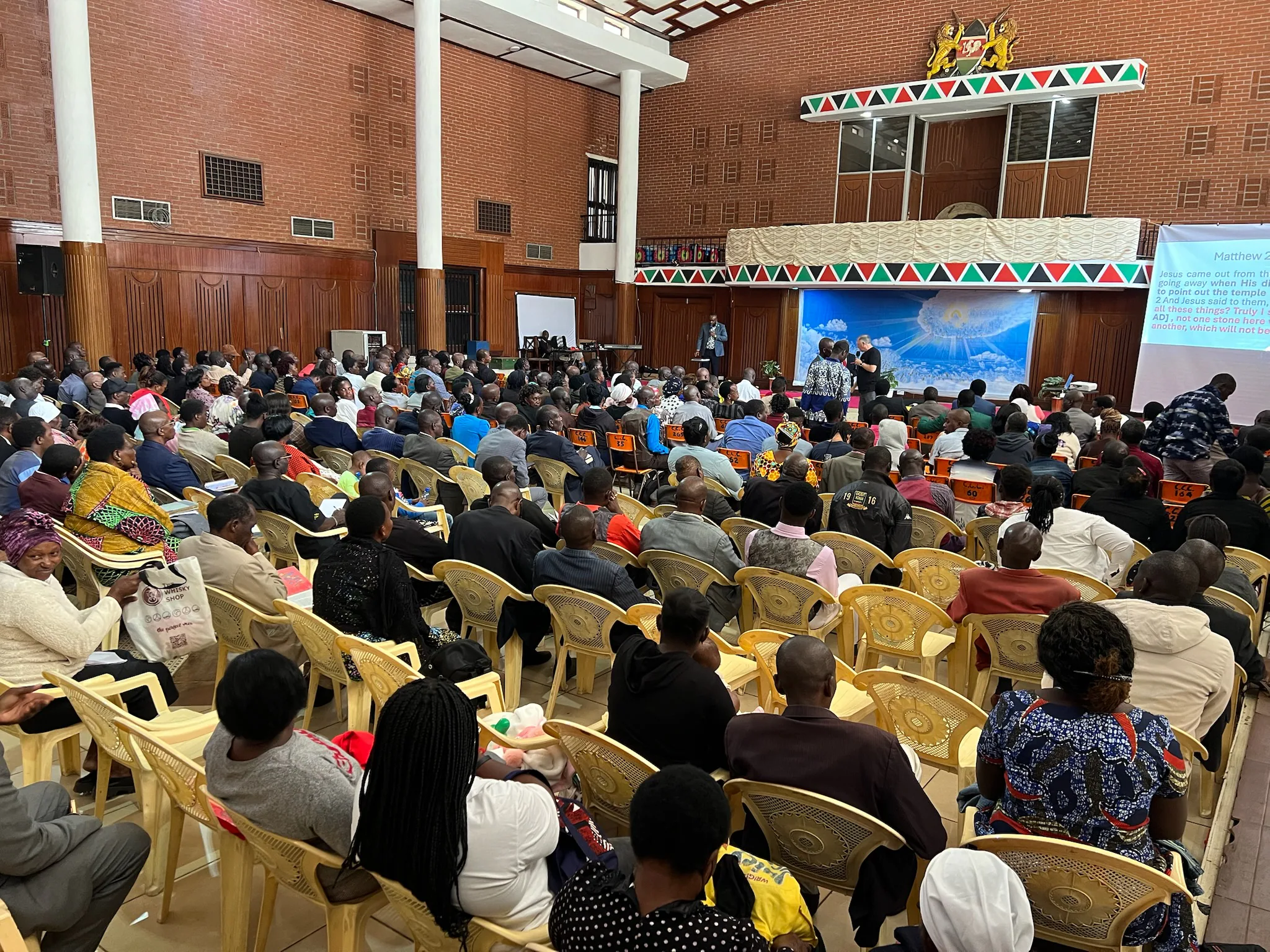 Pastors and ministry leaders fill rows of chairs inside Charter Hall during a conference session.